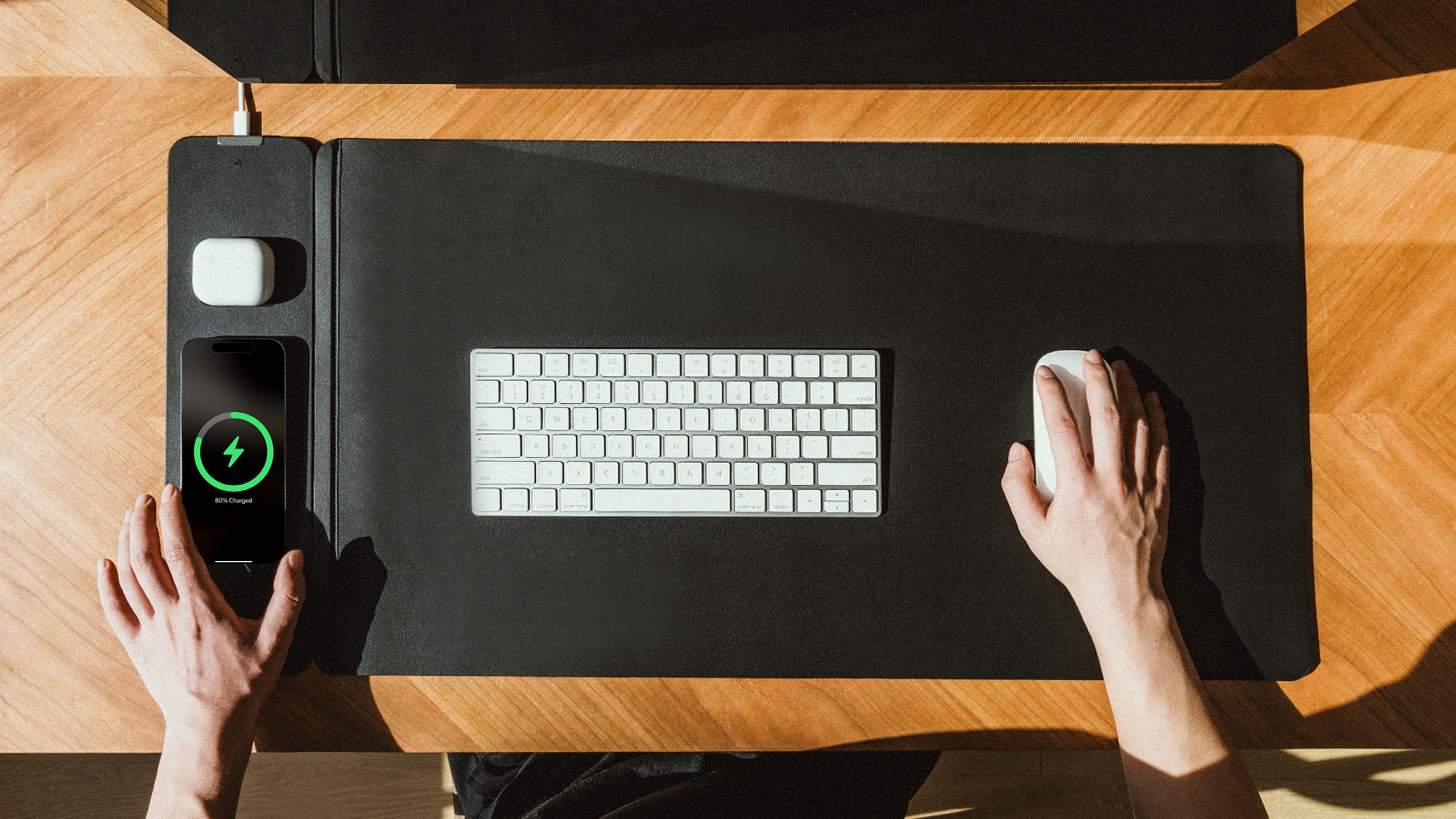 NeoDesk charging desk mat with keyboard, phone, and earbuds, offering wireless charging and a clean, organized workspace for productivity.