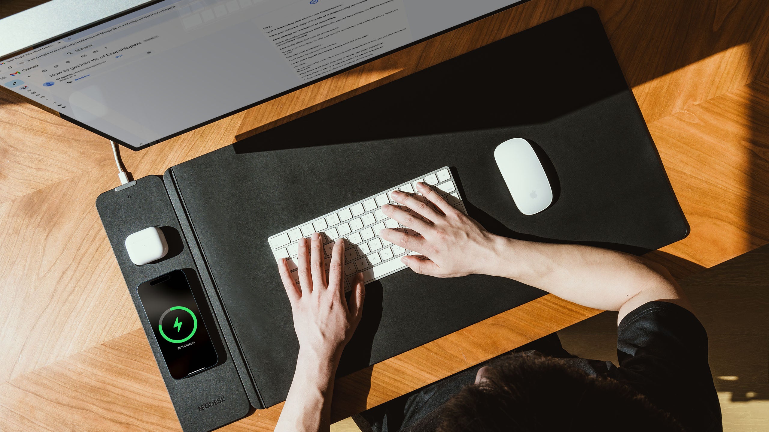 NeoDesk leather charging desk mat banner featuring phone and earbuds charging in a modern workspace.