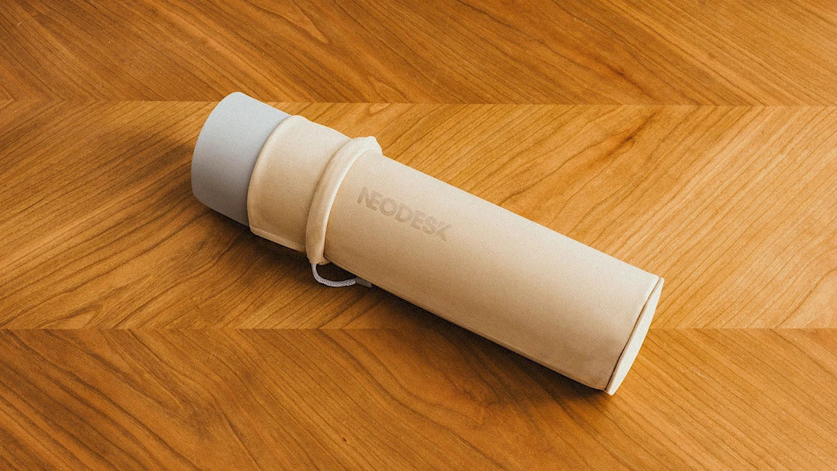 NeoDesk portable charging desk mat rolled up for easy storage and travel, showcasing its compact and versatile design.